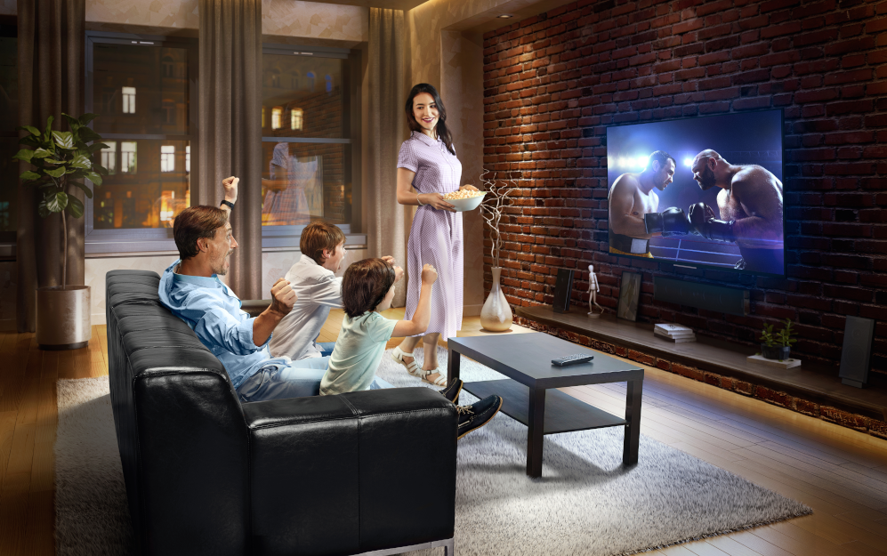 Famille assise devant une télévision pour illustrer ce support publicitaire