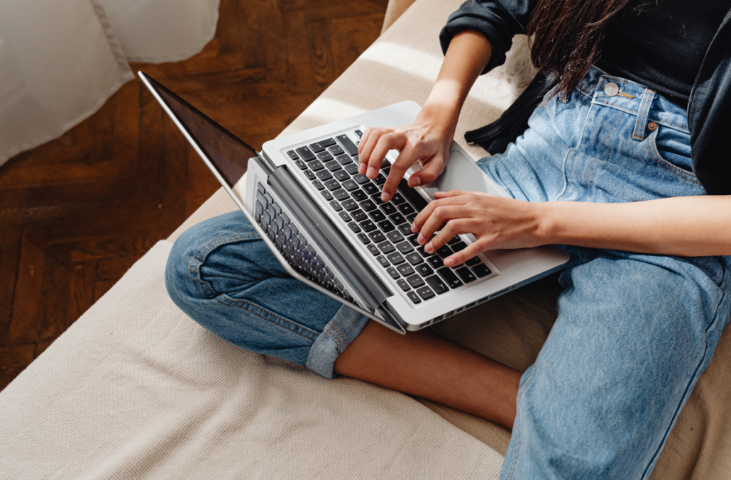 Femme qui écrit sur son ordinateur portable pour illustrer l'accompagnement des experts de l'agence media Mediagenic vers votre visibilité