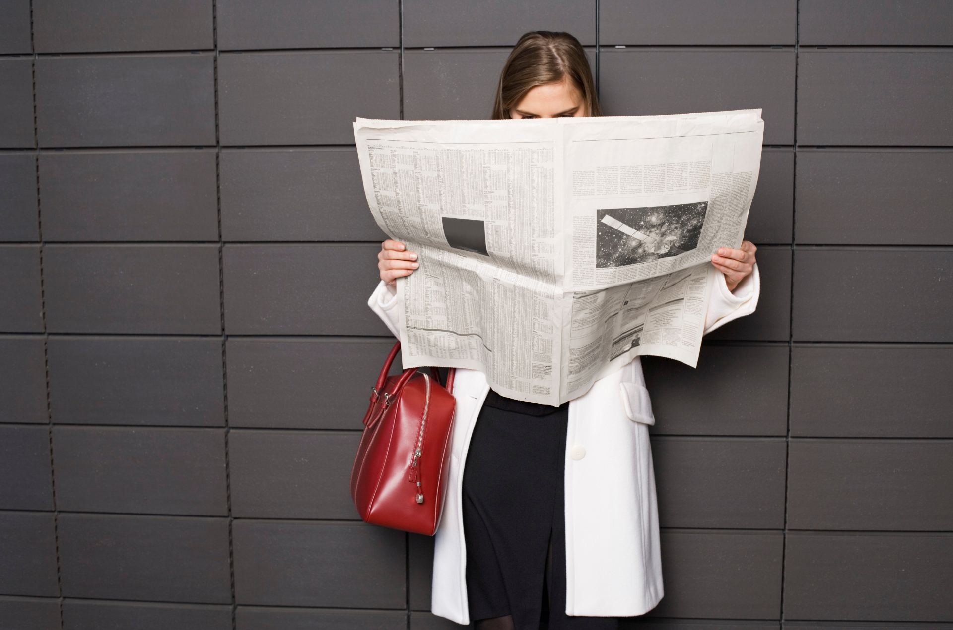 Femme qui lit un journal pour illustrer la possibilité de faire de la publicité dans la presse avec l'accompagnement de l'agence média Mediagenic